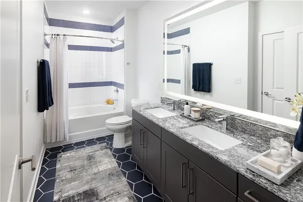 a bathroom with a granite countertop sink toilet and shower