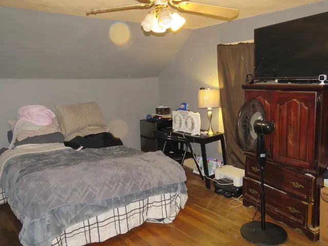 a bedroom with a bed tv and the dresser
