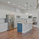 a large kitchen with stainless steel appliances and white cabinets