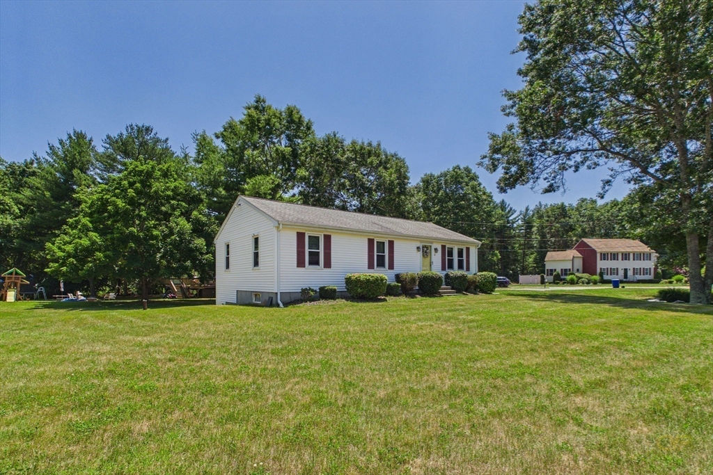 8 Cotuit Road Taunton, MA 02718 - Photo 23 of 24 a house that is sitting in the grass with large trees and plants