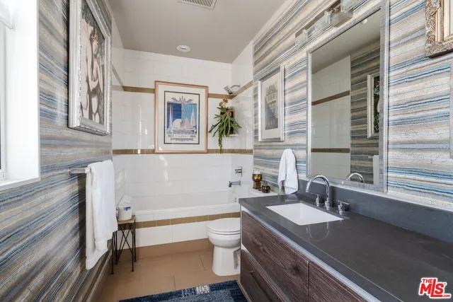 a bathroom with a granite countertop toilet a sink and a bathtub