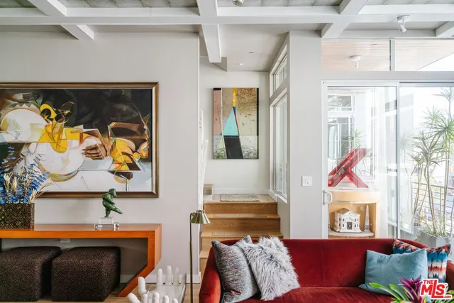 a living room with furniture and wall paintings