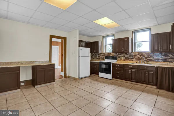 a kitchen with stainless steel appliances granite countertop a stove a sink dishwasher and a refrigerator