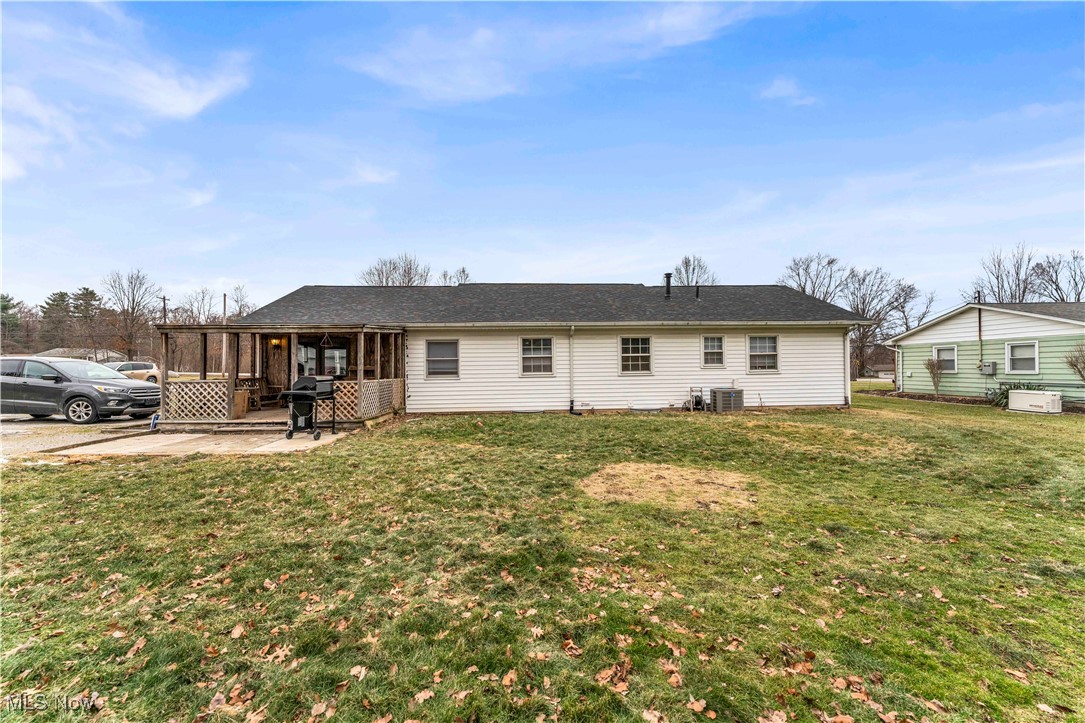14808 Darrow Road Vermilion, OH 44089 - Photo 42 of 45 Rear view of house with cooling unit, a lawn, and a patio area