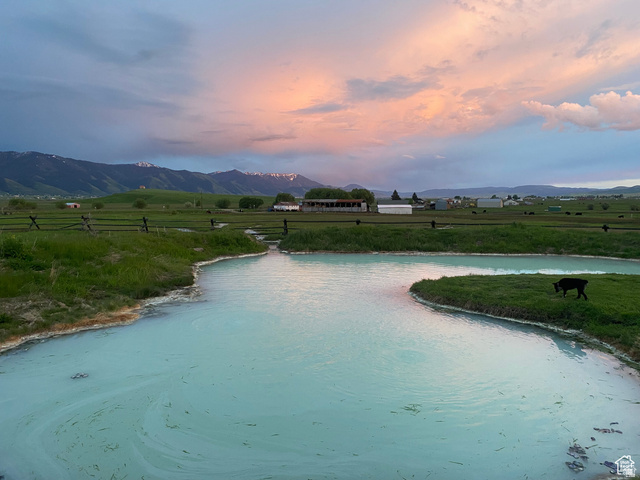 79 Auburn Forest Road Auburn, WY 83111 - Photo 70 of 76 Pool at dusk with a rural view, a lawn, and a water and mountain view