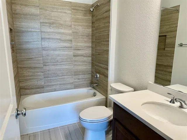 a bathroom with a granite countertop toilet sink and mirror