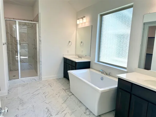 a bathroom with a tub sink and mirror
