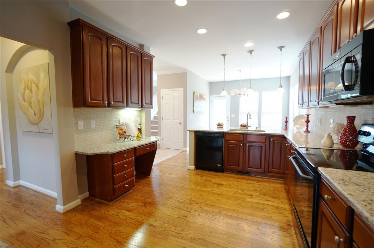 7730 San Gabriel Street Raleigh, NC 27613 - Photo 3 of 25 Spacious kitchen has an open layout, granite counter tops, tile back splash, under cabinet lighting, charm, style & sophistication. Kitchen