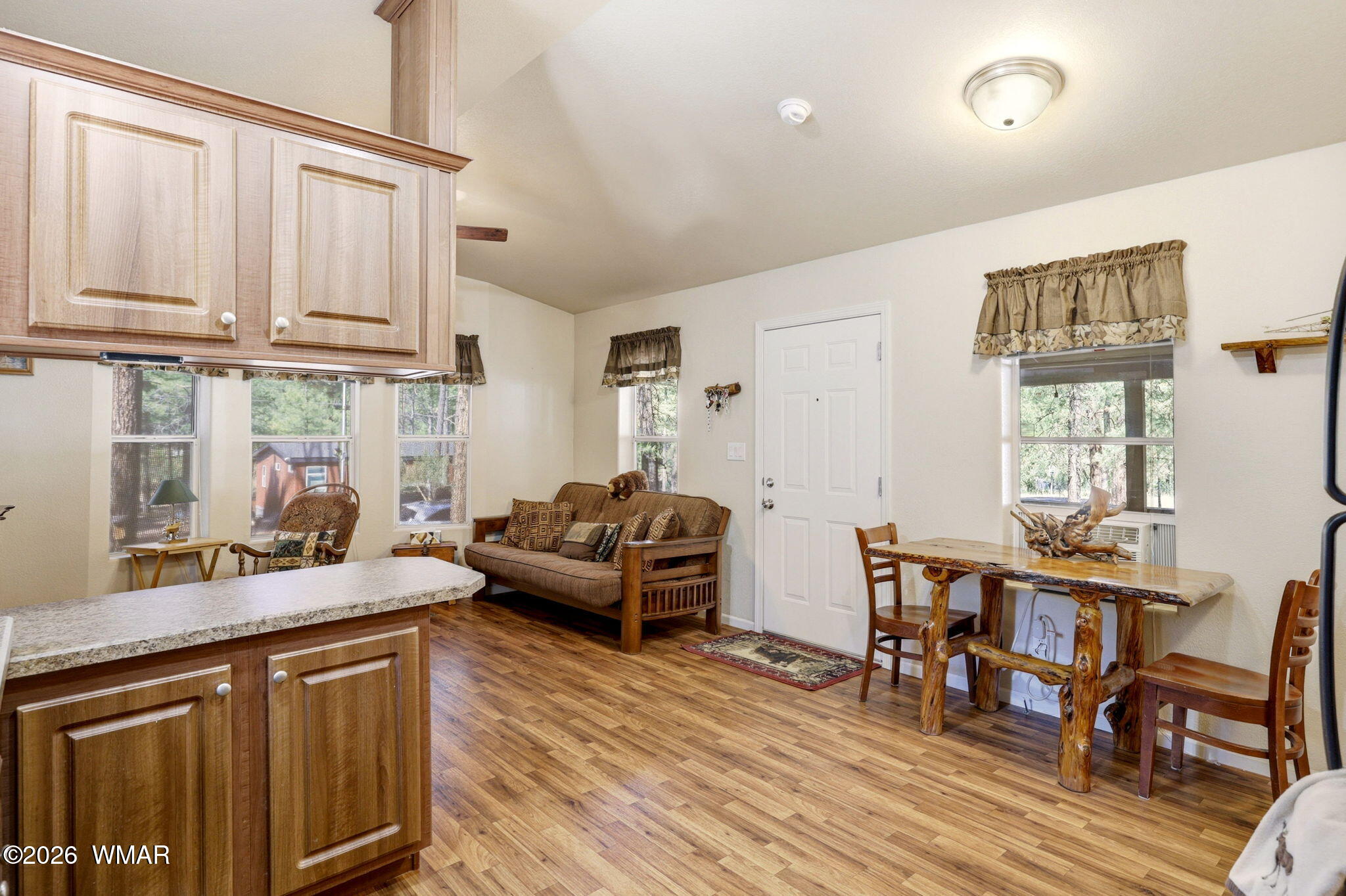 2893 Tracy Road Overgaard, AZ 85933 - Photo 12 of 26 a kitchen with stainless steel appliances granite countertop a stove a sink dishwasher and a dining table with wooden floor