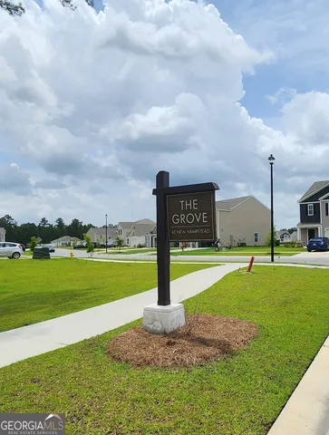a sign board with a yard in back
