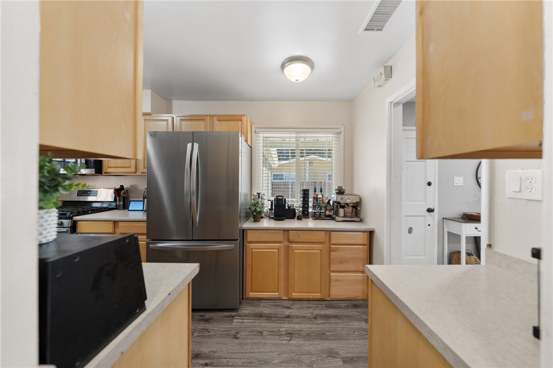 4869 Serrano Place Riverside, CA 92504 - Photo 21 of 40 Bright kitchen with stainless steel appliances, abundant cabinetry, and a functional layout designed for everyday convenience.