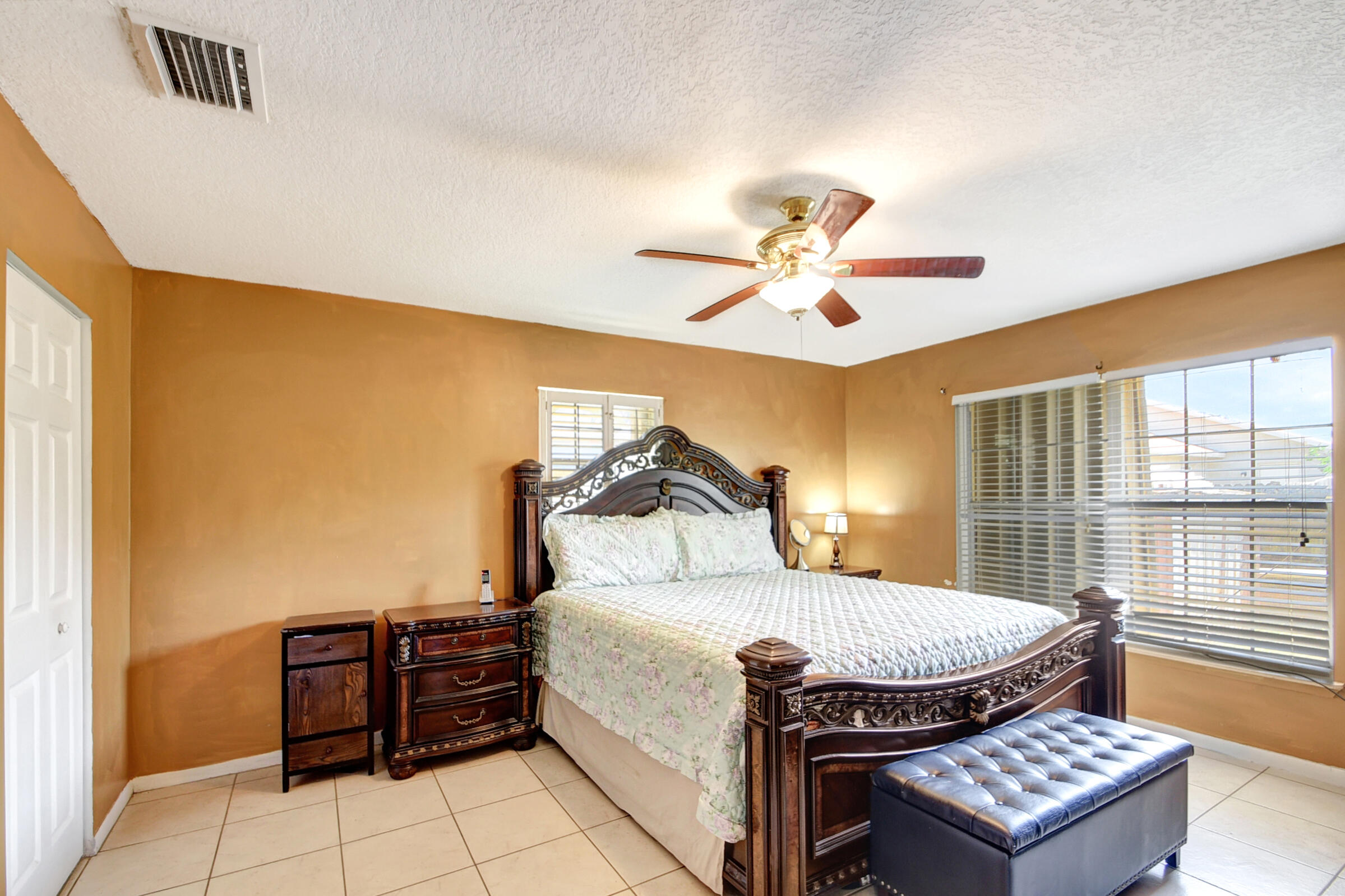 10128 Boynton Pl Circle Boynton Beach, FL 33437 - Photo 11 of 25 a bed sitting in a bedroom next to a window