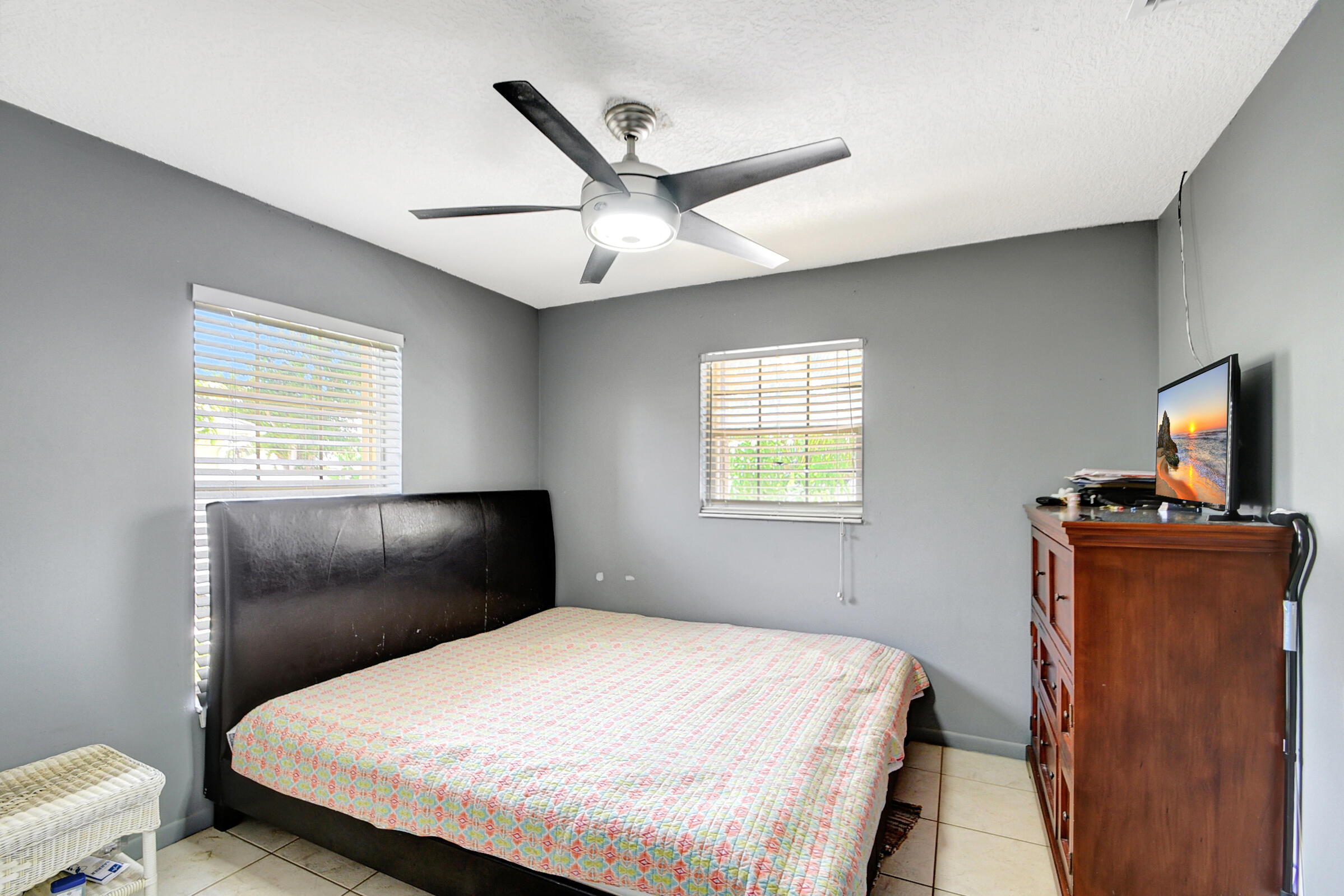 10128 Boynton Pl Circle Boynton Beach, FL 33437 - Photo 14 of 25 a bedroom with a bed and a flat tv screen on the dresser