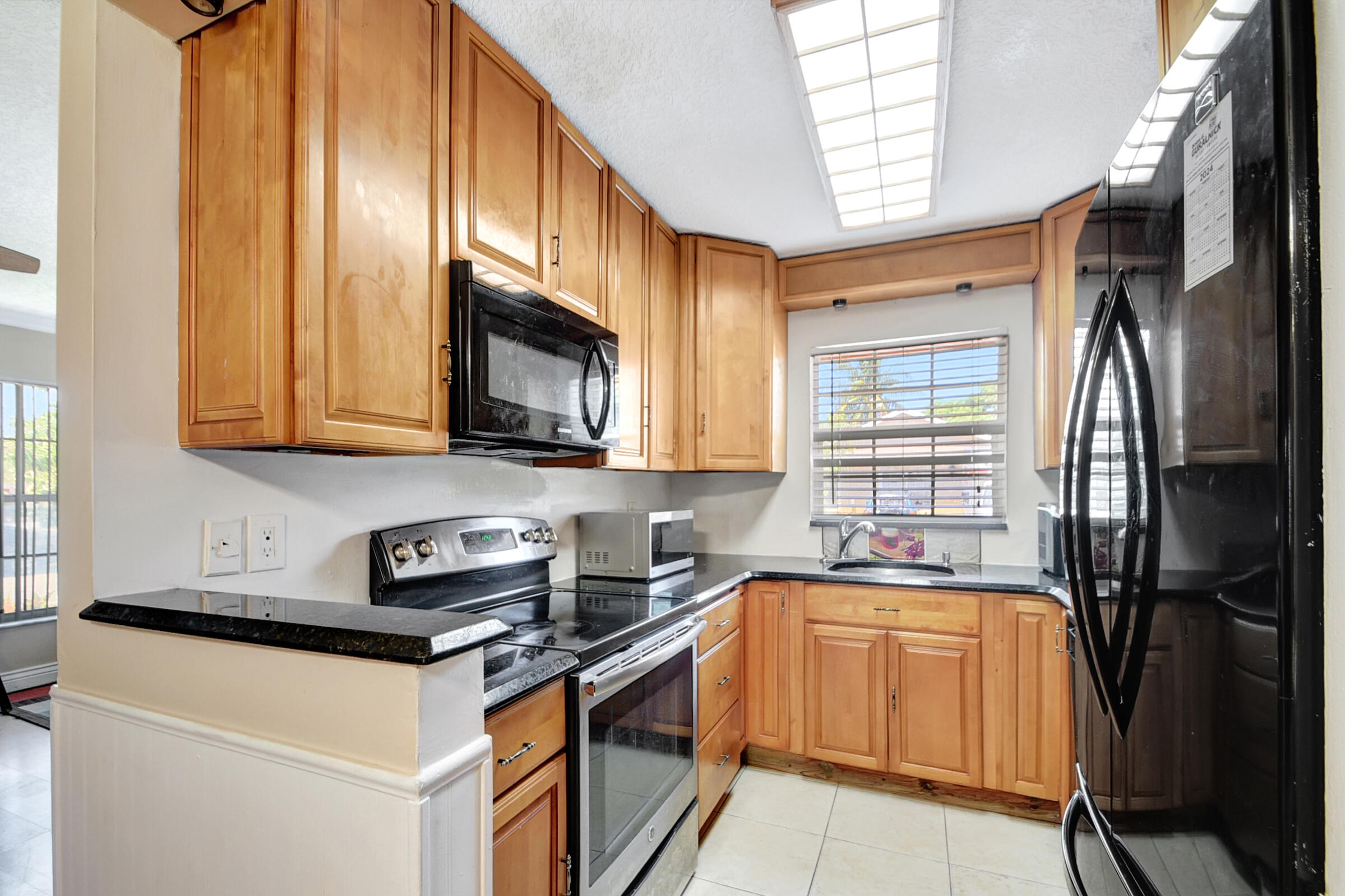 10128 Boynton Pl Circle Boynton Beach, FL 33437 - Photo 8 of 25 a kitchen with stainless steel appliances granite countertop a stove a sink and a microwave