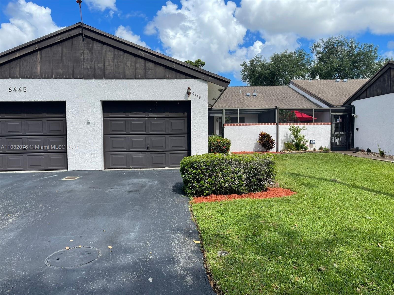 6449 Pinehurst Circle, Unit C25 Tamarac, FL 33321 - Photo 1 of 22 a front view of a house with a yard and garage