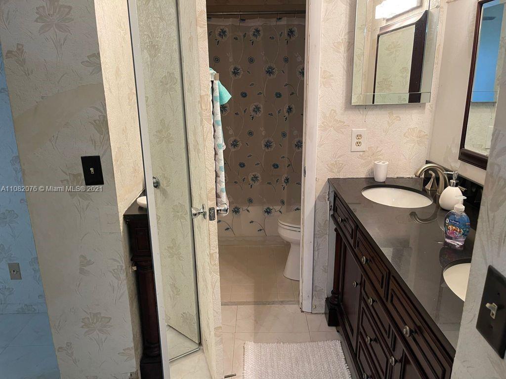 6449 Pinehurst Circle, Unit C25 Tamarac, FL 33321 - Photo 11 of 22 a bathroom with a granite countertop sink a mirror and shower
