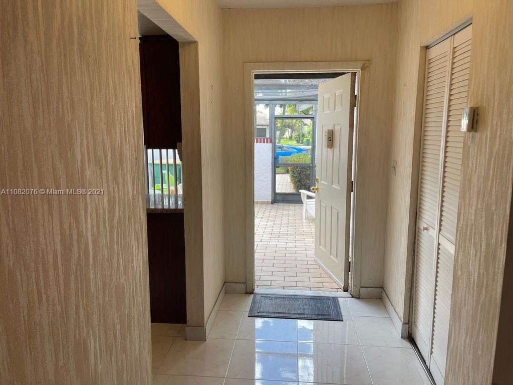 6449 Pinehurst Circle, Unit C25 Tamarac, FL 33321 - Photo 13 of 22 a view of a hallway with wooden floor and a room