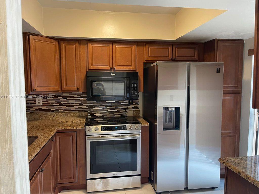 6449 Pinehurst Circle, Unit C25 Tamarac, FL 33321 - Photo 14 of 22 a kitchen with a refrigerator stove and microwave