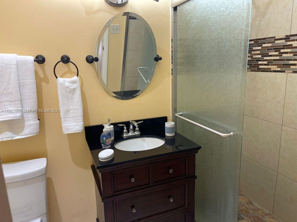 6449 Pinehurst Circle, Unit C25 Tamarac, FL 33321 - Photo 6 of 22 a bathroom with a sink and a mirror