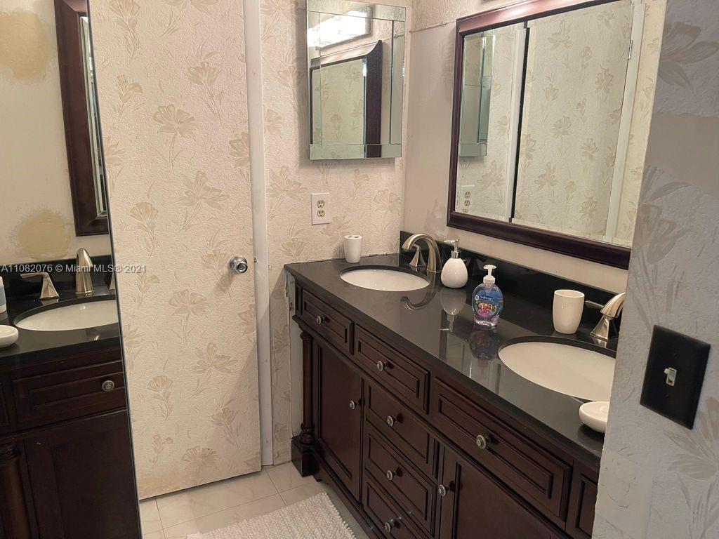 6449 Pinehurst Circle, Unit C25 Tamarac, FL 33321 - Photo 8 of 22 a bathroom with a granite countertop sink and a mirror