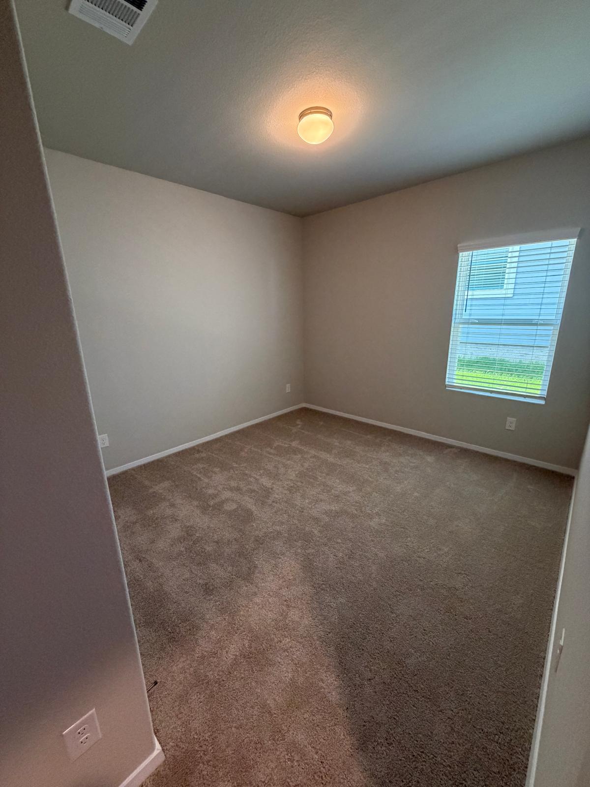 2701 Towy Road Manor, TX 78653 - Photo 14 of 35 A well-lit room offers ample space, awaiting your personal touch.
