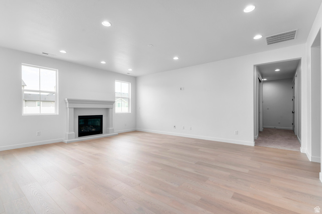 1869 South 2425 West Ogden, UT 84401 - Photo 10 of 22 Unfurnished living room with recessed lighting, a glass covered fireplace, and light wood-style flooring