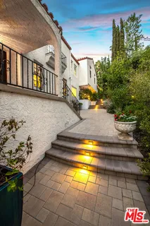 a kitchen with stainless steel appliances granite countertop a table chairs sink and cabinets