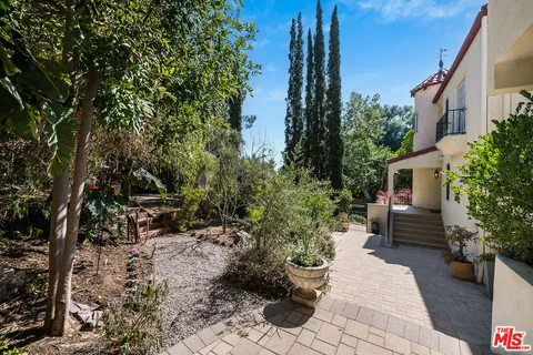 a kitchen with stainless steel appliances granite countertop a stove top oven a sink dishwasher and a refrigerator with wooden floor