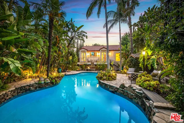 a front view of a house with swimming pool and sitting area
