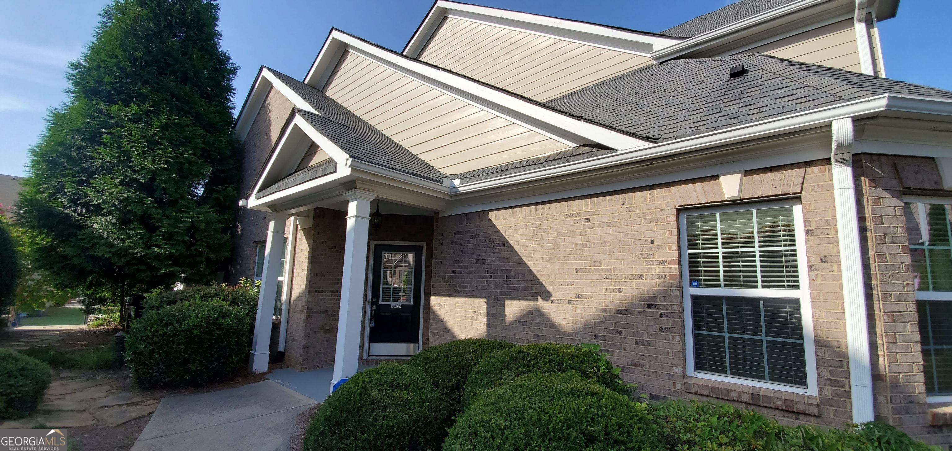 a view of a house with brick walls and a large window