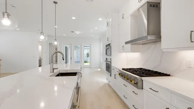 a kitchen with stainless steel appliances a stove a sink a refrigerator and cabinets