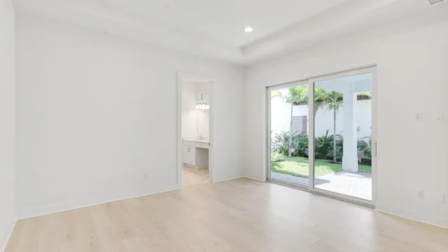 an empty room with large windows and wooden floor