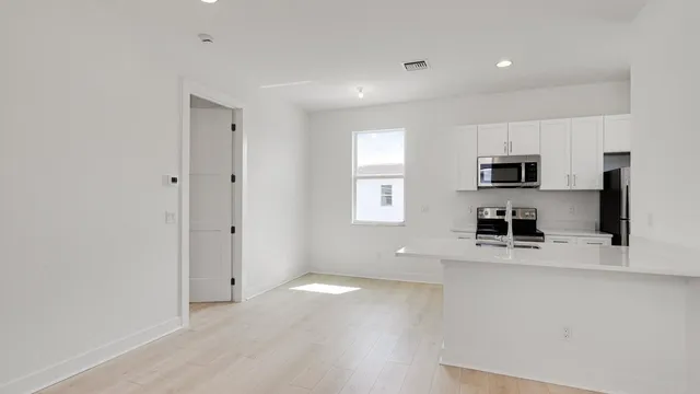 a kitchen with stainless steel appliances granite countertop a sink and a refrigerator