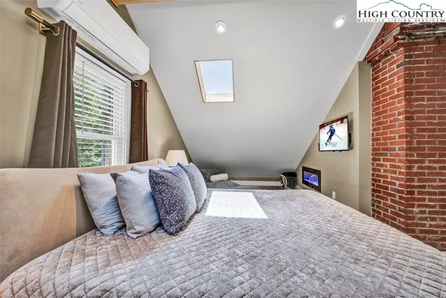 a bedroom with a bed and a large window