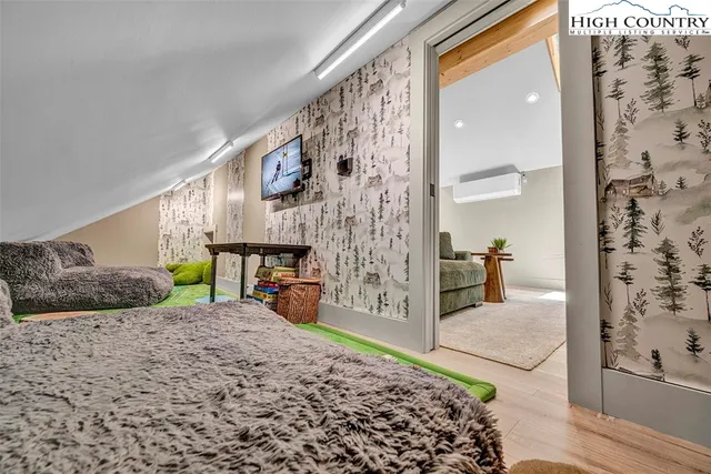 a bedroom with a bed and a large mirror on the dresser