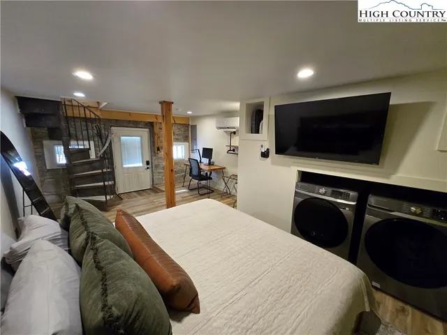 a bedroom with a bed and a flat screen tv
