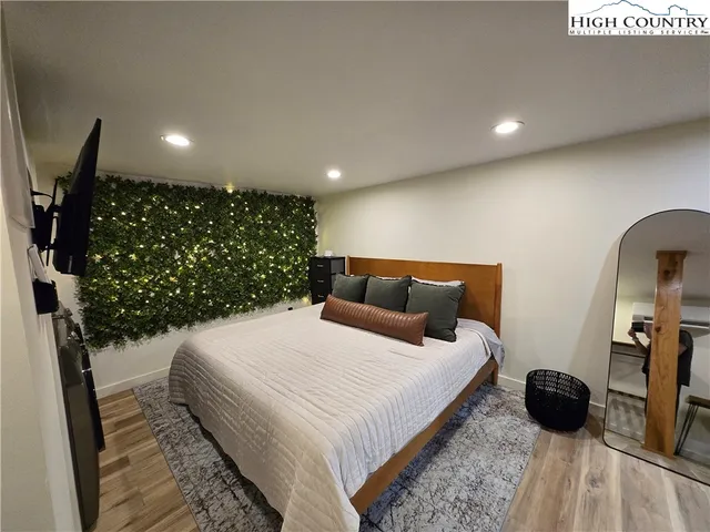 a bedroom with a bed a mirror and dresser