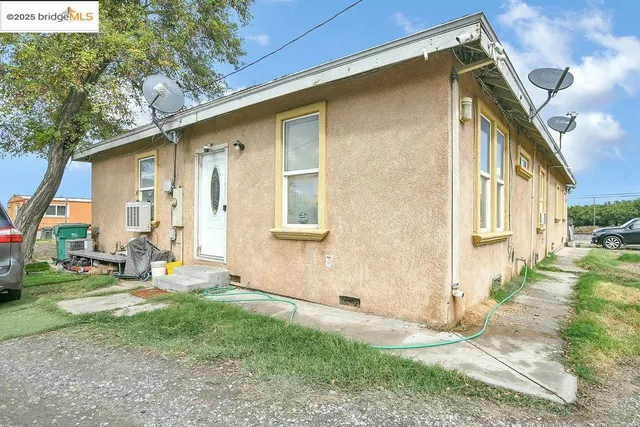 a view of a house with a yard and lawn chairs