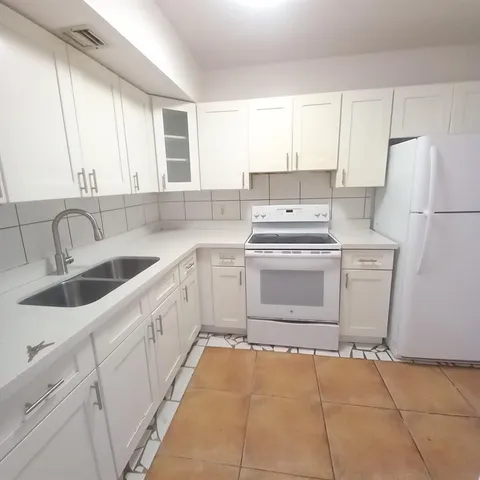 a kitchen with a stove sink and cabinets