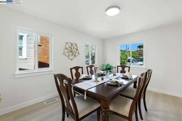 a view of a dining room and livingroom with furniture wooden floor and a rug