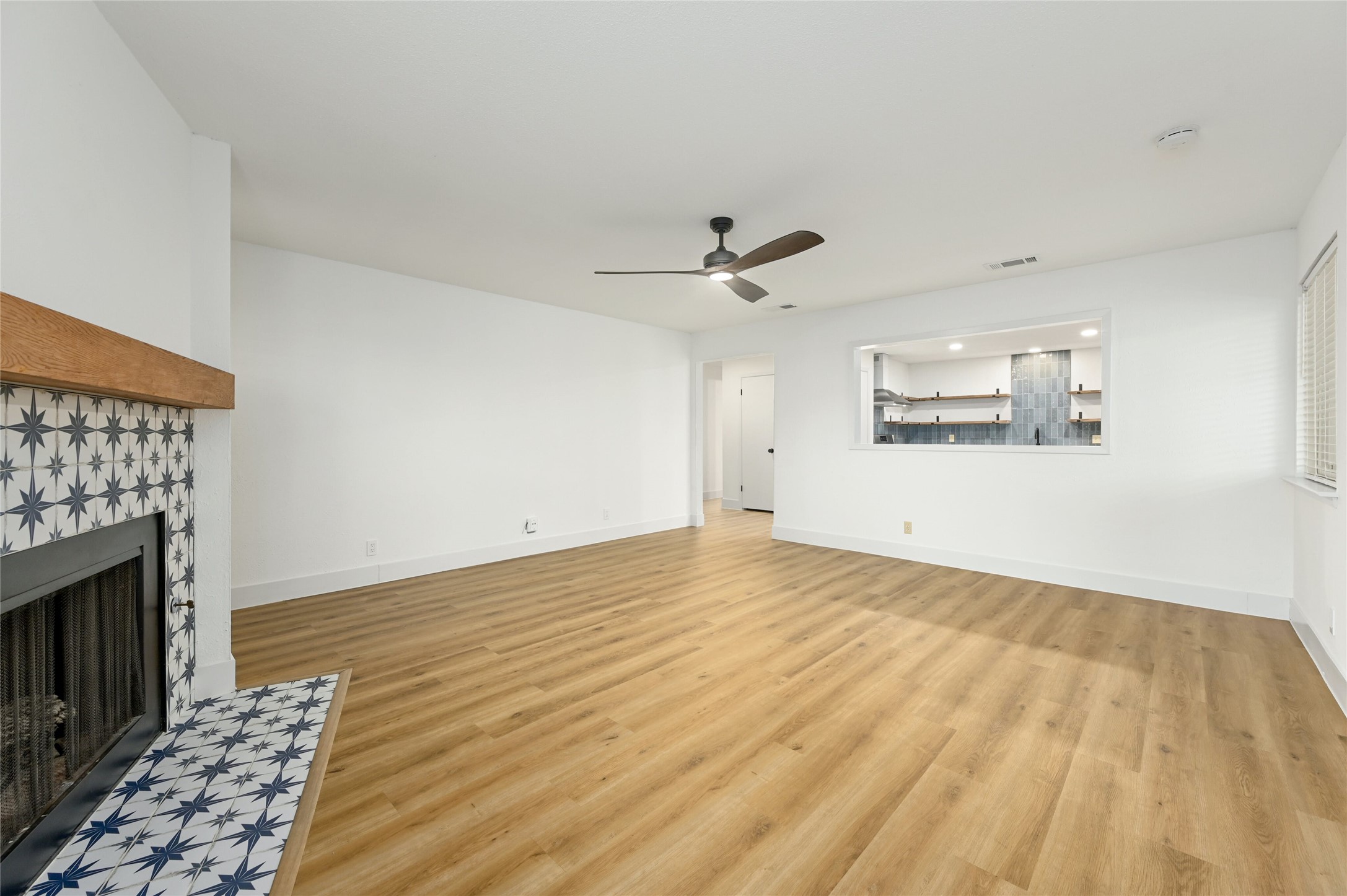 4808 Wind River Road Austin, TX 78759 - Photo 4 of 21 Warm wood-style floors and a tiled fireplace ground this welcoming, open-concept living space.