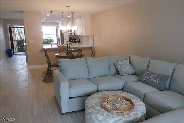 a living room with furniture kitchen and a chandelier