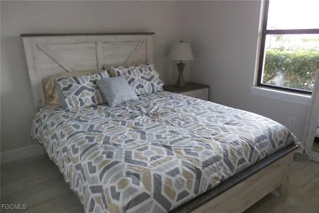 a large bed sitting in a bedroom next to a window