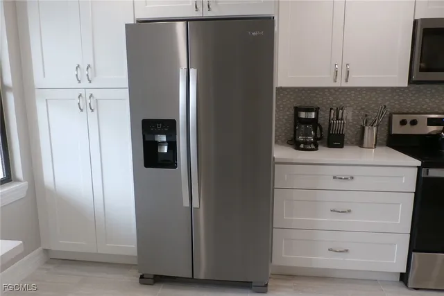 a kitchen with a refrigerator and cabinets