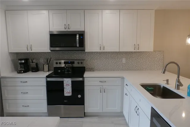 a kitchen with white cabinets and stainless steel appliances