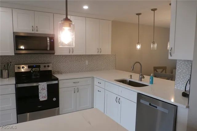 a kitchen with stainless steel appliances granite countertop a sink a stove a microwave and cabinets