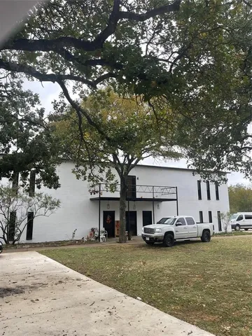 a view of a yard in front of a house with cars parked