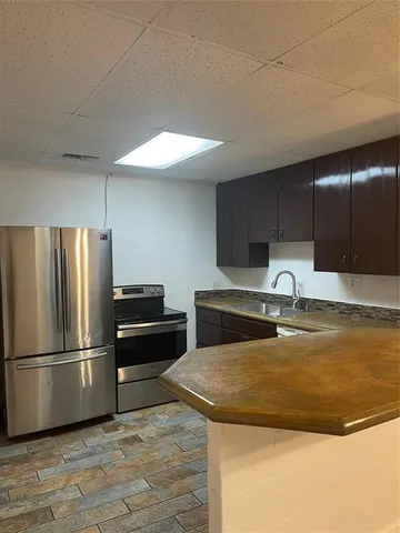 a kitchen with granite countertop a refrigerator and a sink