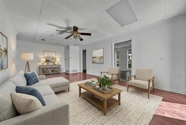 a living room with furniture and a wooden floor