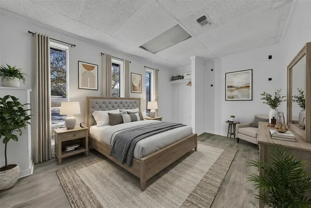 a spacious bedroom with a bed and a potted plant